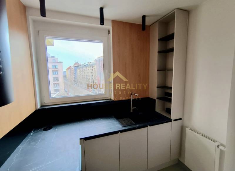 Kitchen in a 2-room apartment with a view of the city, floor with wood decor.