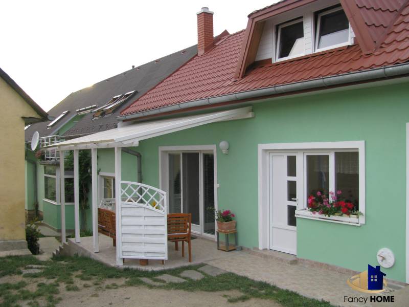 A family house on Mieru Street in Poproč with a terrace and a pink roof.