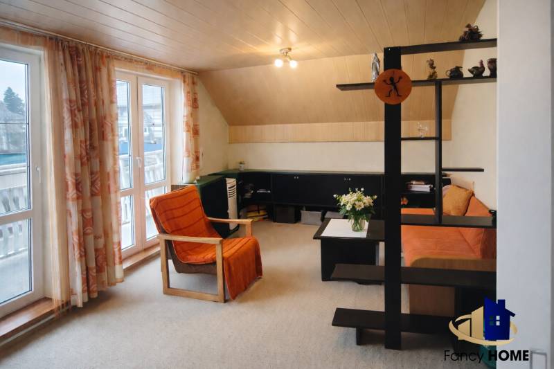 Living room with an orange armchair and sofa in a family house.