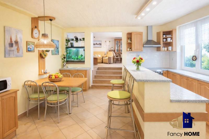 Kitchen and dining room with a bar in a family house, light shades and an aquarium.