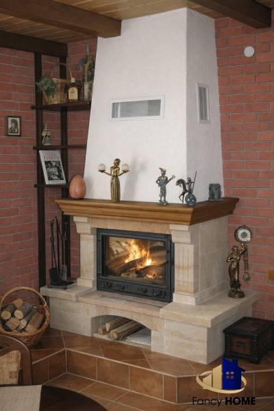 Fireplace in a family house, surrounded by a brick wall with decorative figurines and a basket of wood.
