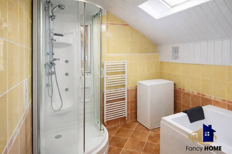 A bathroom in a family house with a corner shower, bathtub, and washing machine.