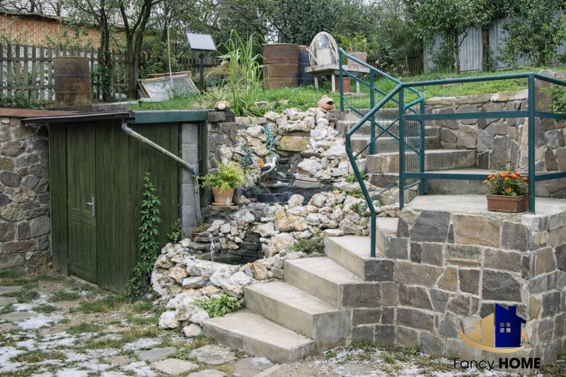 The exterior of a family house on Mieru Street in Poproč, with a staircase and floral decorations.