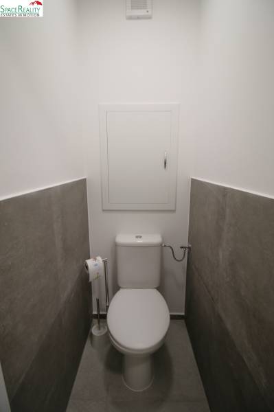 A toilet with ceramic tiles in a 3-room apartment.