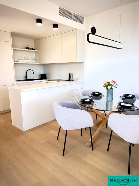 A kitchen in a 3-room apartment with a wooden decor floor, dining table, and chairs.
