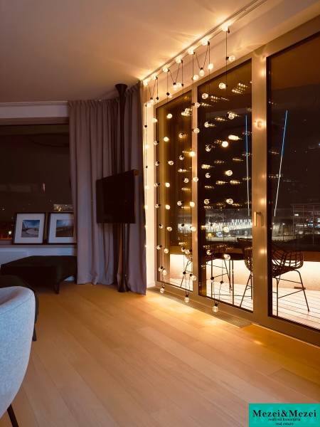 Interior of a 3-room apartment with light decoration, curtains, and a wooden decor floor.