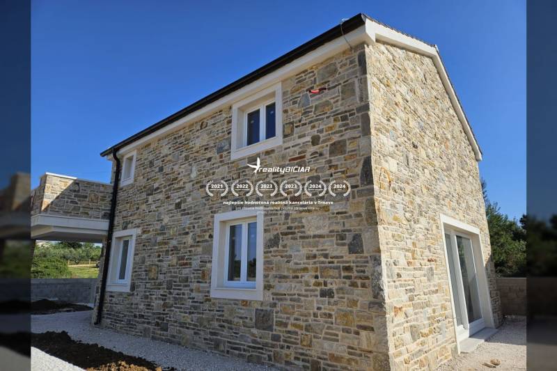 A family house in the town of Vrsi on Vrsi Street with a stone facade and white windows.