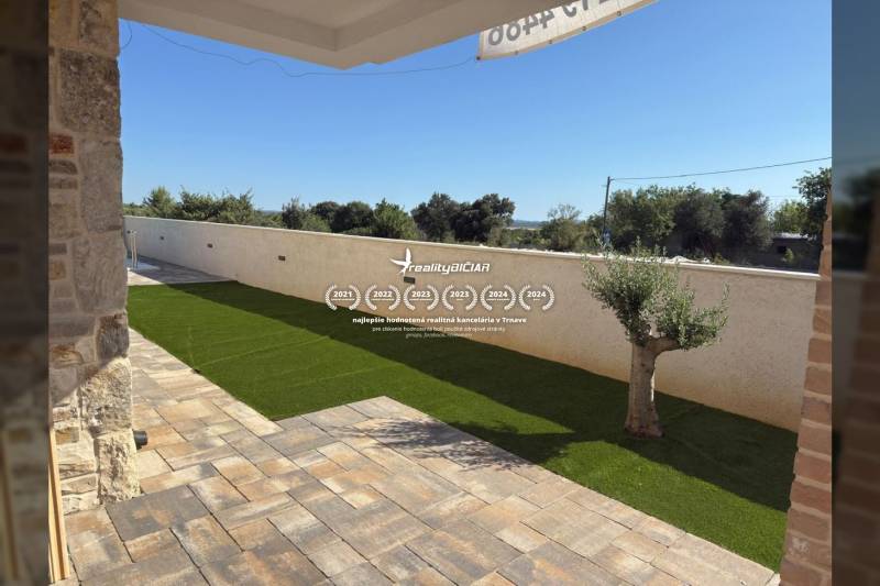 Stone terrace with artificial grass at a family house in Vrsi on Vrsi Street.
