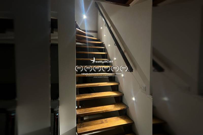 Wooden stairs in a family house with LED lighting installed along the wall.