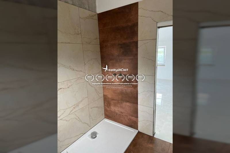 A bathroom in a family house with ceramic tiles and a shower enclosure.
