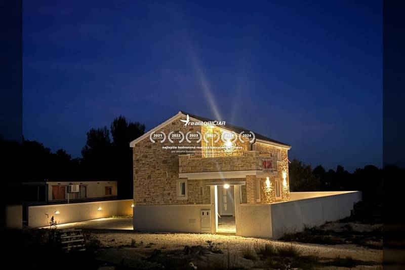 A family house on Vrsi Street in the town of Vrsi in a nighttime atmosphere with lighting.