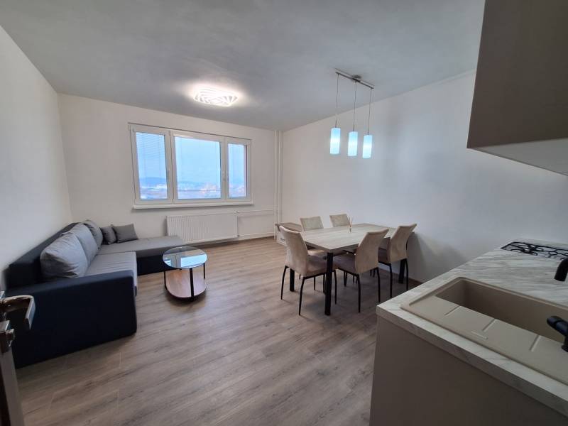 Interior of a 2-room apartment with a wooden decor floor, sofa, and dining table.