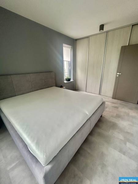 Bedroom with a bed and built-in wardrobe in a 2-room apartment, floor with wooden decor.