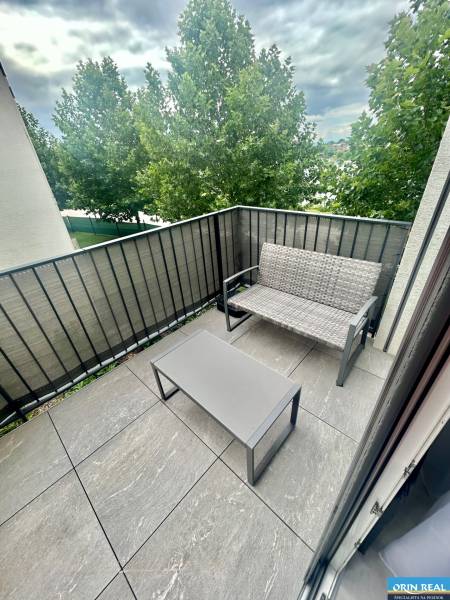 A balcony with seating and a view of the trees, a 2-room apartment on Golfová Street, Hrubá Borša.