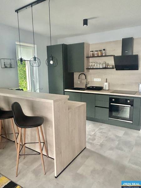 A kitchen corner with dark furniture and decorative lighting in a 2-room apartment.