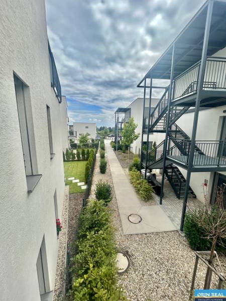 New buildings on Golfová Street in Hrubá Borša with landscaped exteriors and greenery.