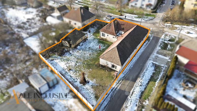 Plots for residential use in Zemné with snow-covered roofs and a garden bordered by an orange line.