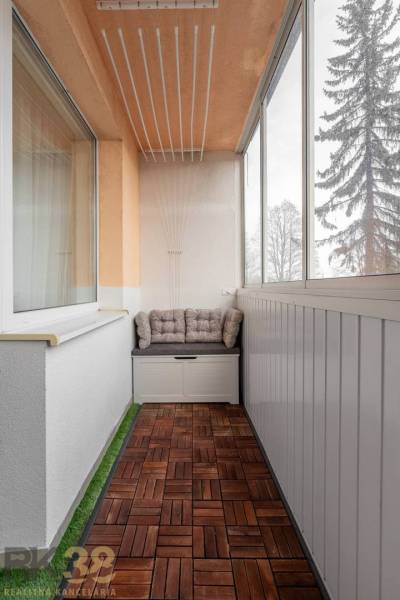 Glazed loggia with a wooden decor floor in a 3-room apartment.