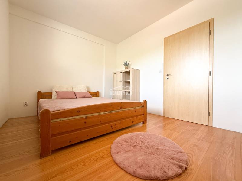 A bedroom with wooden furniture and a floor with a wooden decor in a 2-room apartment.