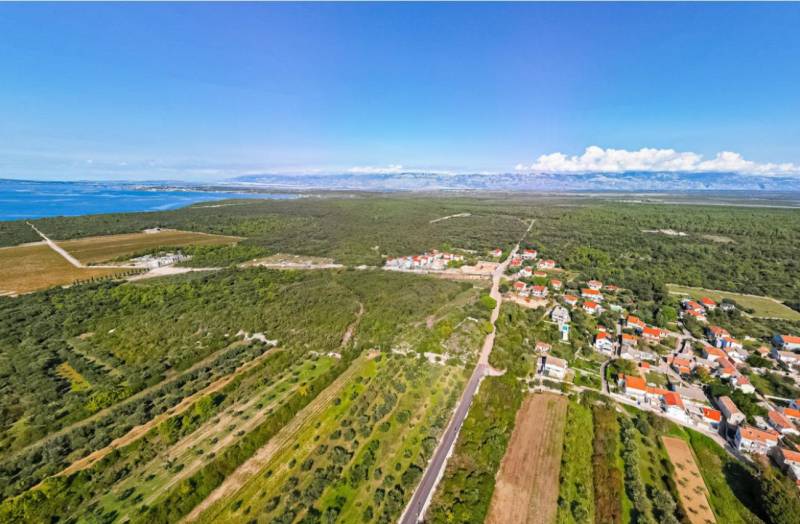 Aerial view of the landscape in PETRČANE with rural houses and fields near 2-bedroom apartments.