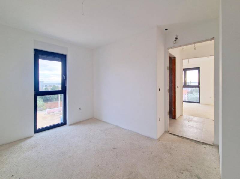 Interior of a 3-room apartment with white walls and a large window.