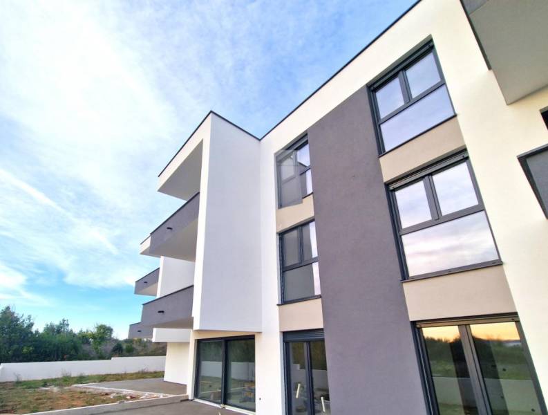 A new building with balconies in the town of Privlaka offers three-room apartments and a garden.