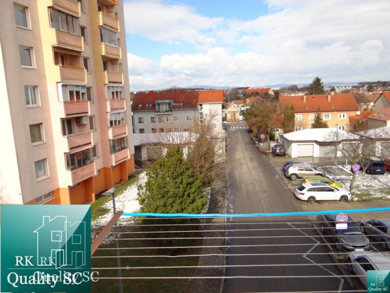 1st May Square Street in Senec with apartment buildings and a parking lot.