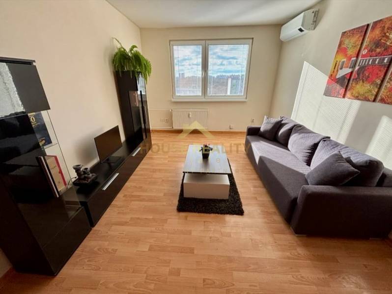Living room in a 3-room apartment with a sofa, television, cabinet, and floor with wooden decor.