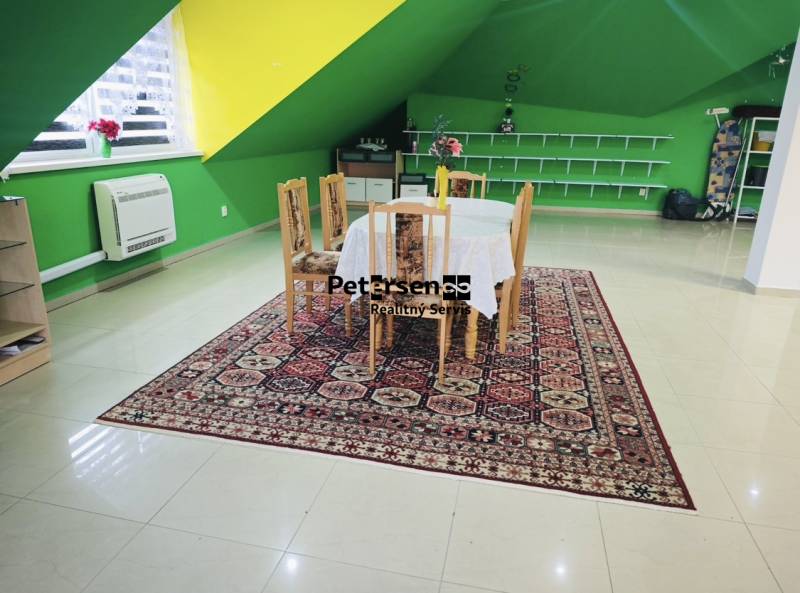 Interior of a family house with a dining table, colorful walls, and a patterned carpet.