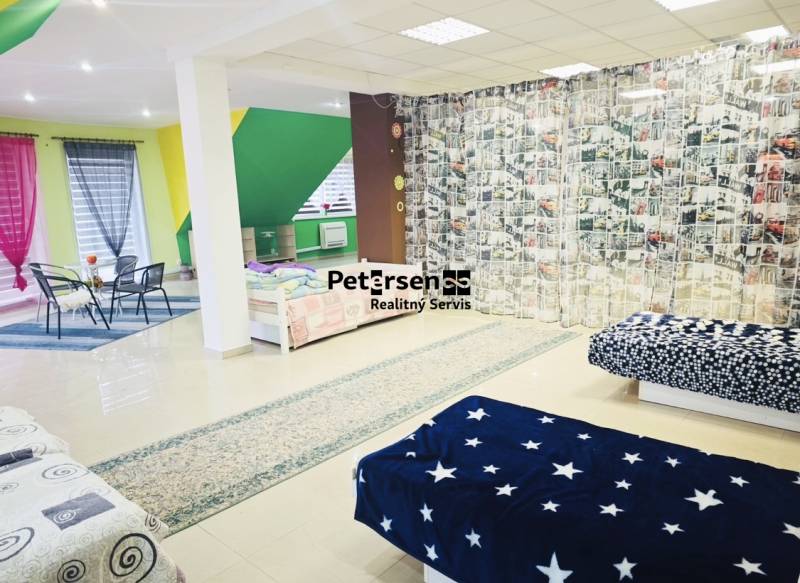 A spacious room in a family house with colorful elements and various bedspreads.