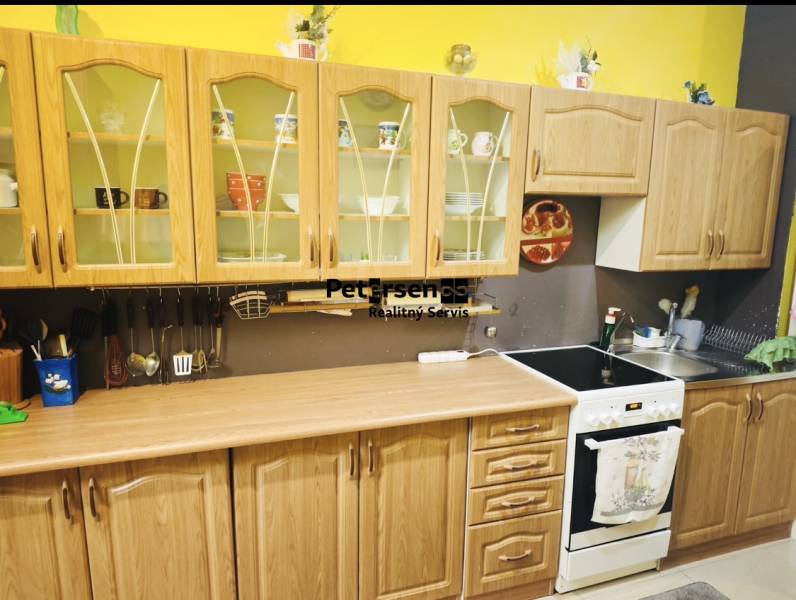 A kitchen in a family house with wooden cabinets and an electric stove.