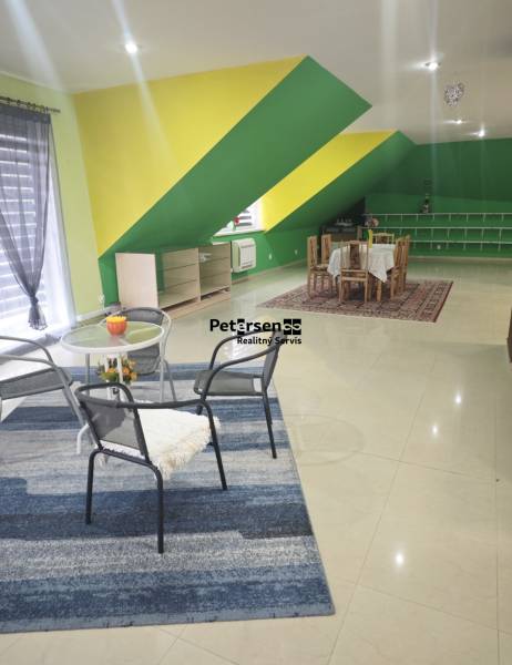 Interior of a family house with colorful walls, carpet, furniture, and dining table.