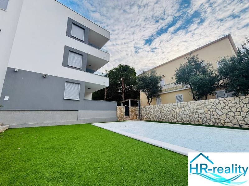 A holiday apartment in Novalja with a swimming pool and landscaped garden, modern architecture.