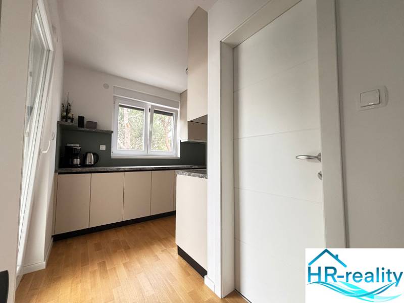 Recreational apartment with a kitchen, appliances, and a wooden decor floor.