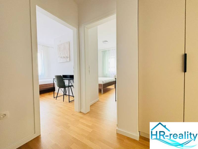 A bright hallway with a wood-patterned floor in a holiday apartment.