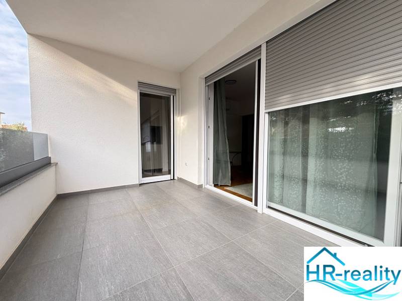 The balcony of the holiday apartment in Novalja, fully covered with a view, gray tiles.