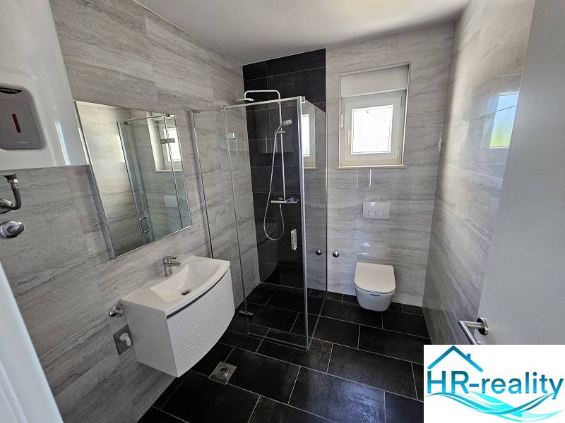 Bathroom in a holiday apartment with a modern shower and a wall-hung toilet.