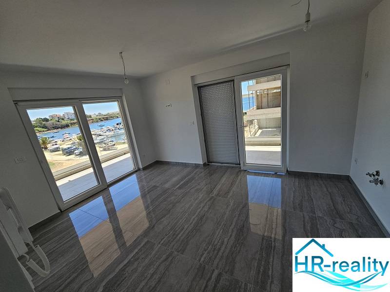 Interior of a holiday apartment with large windows and a view of the Povljana coastline.