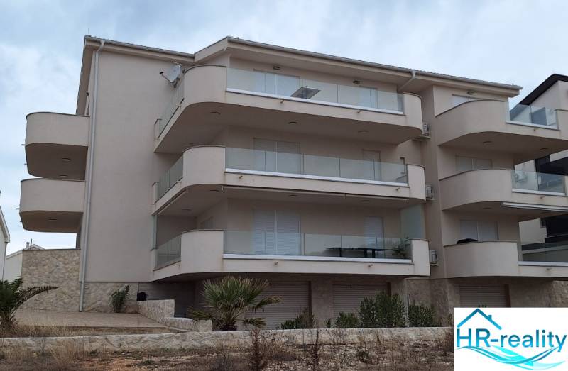 Exterior of a holiday apartment in Povljana with large balconies and minimalist design.