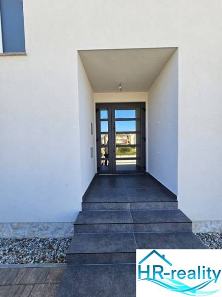 Entrance to the Recreational Apartment in Povljana with dark tiles and glass doors.
