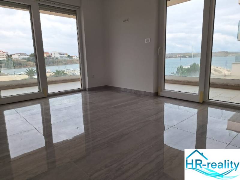 Interior of a holiday apartment with large windows and wood-decor flooring, sea view.