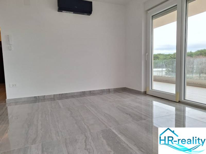 Recreational apartment with modern flooring, large window, and balcony.