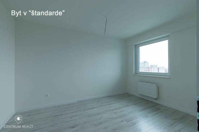 A room with a wooden floor decor, a window, and a radiator in a 2-room apartment.
