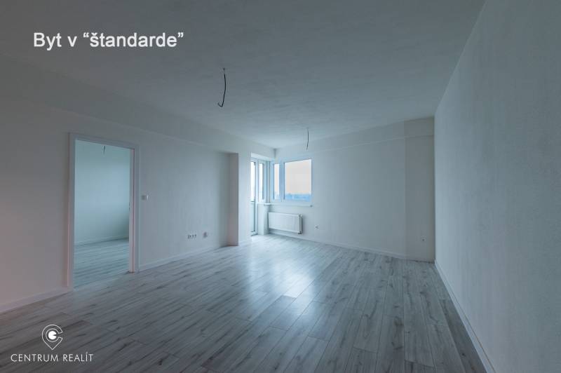 Spacious living room in a 2-room apartment with a wooden decor floor.