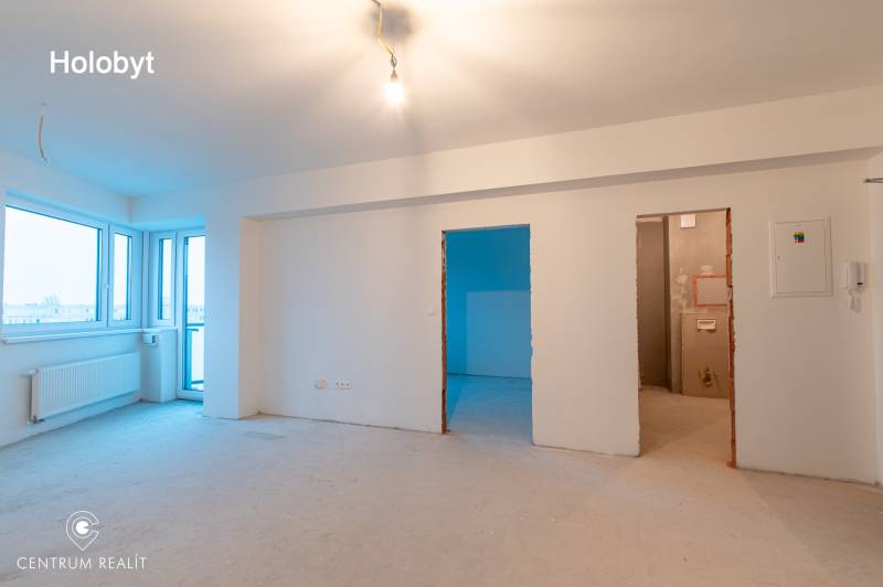An empty 2-room apartment with white walls and an unfinished floor, waiting to be furnished.