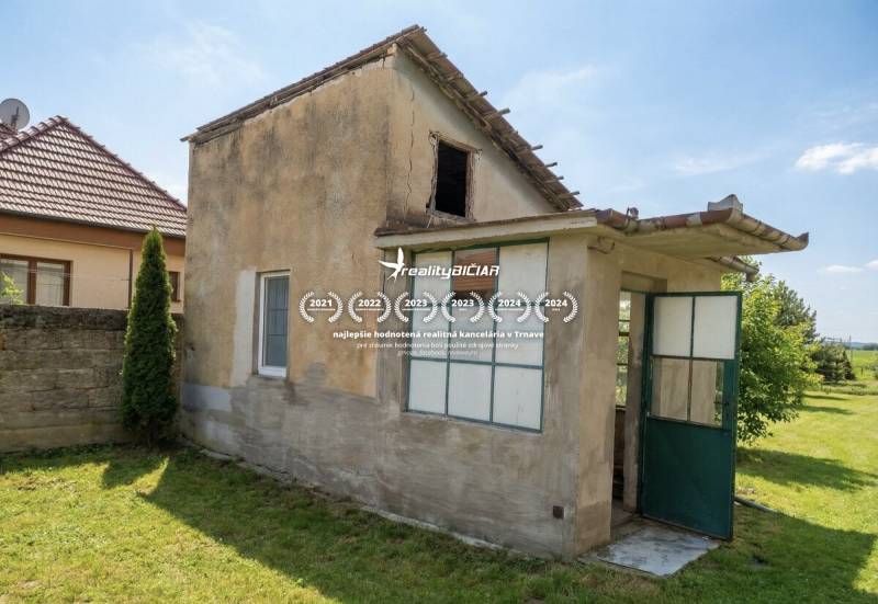 The back part of a family house in Siladice with open doors and a lawn.