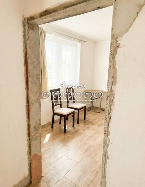 Interior of a family house with two chairs and a wooden-patterned floor.