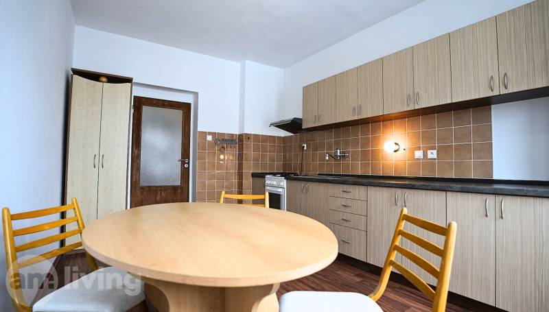 A kitchen in a 3-room apartment with wooden furniture and a floor with a wooden decor.