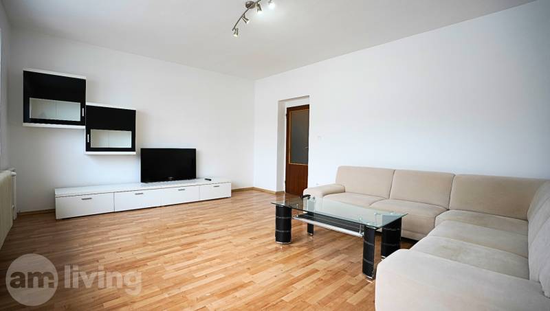 Living room in a 3-room apartment with a corner sofa, TV, and floor with a wooden decor.