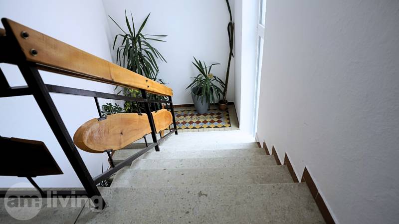 A staircase with plants and a tiled floor in a 3-room apartment.